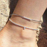 Elegant anklet featuring thread chain and silver bar accent, perfect jewelry piece for a stylish casual look.