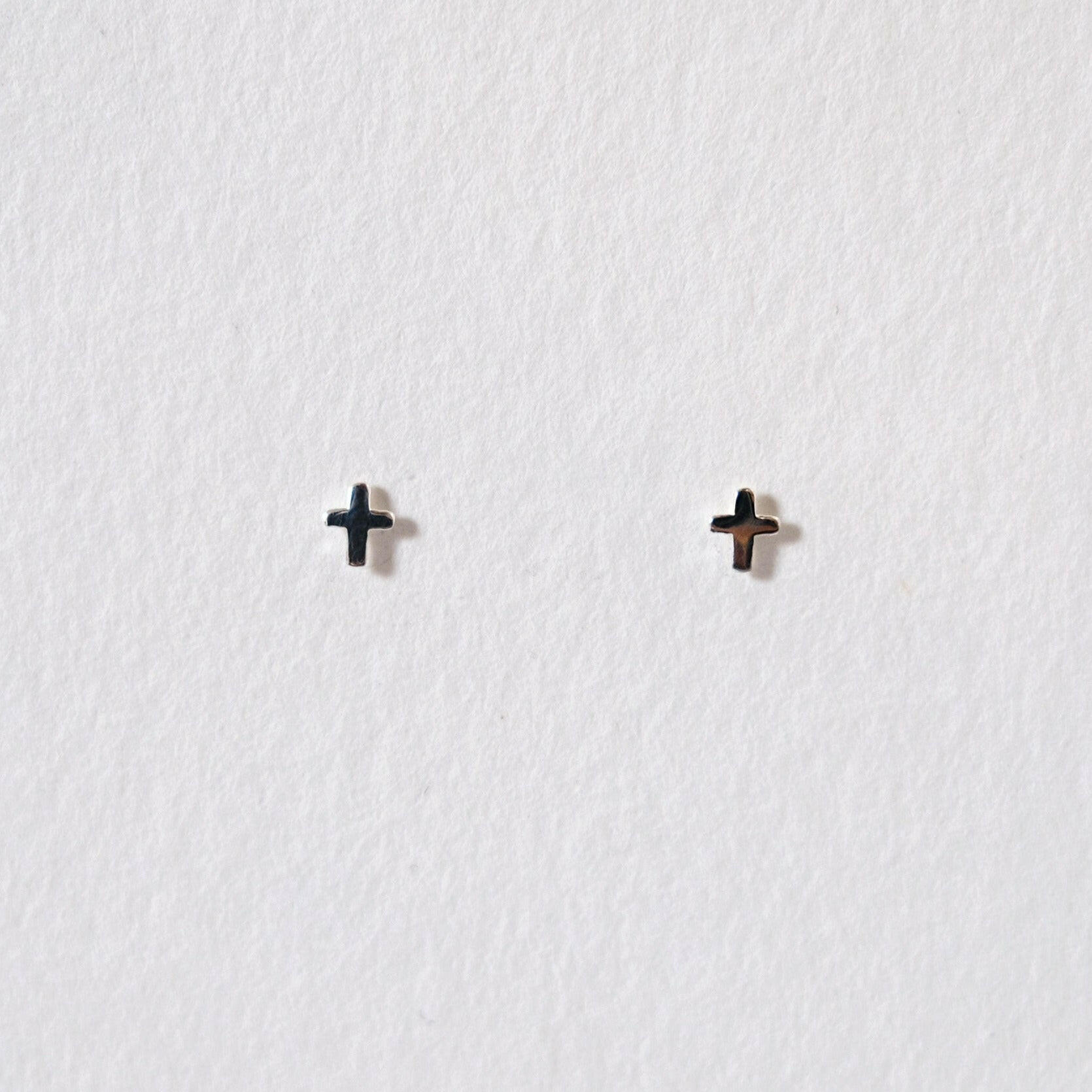 Tiny cross studs in sterling silver featuring minimal symbolism and a sleek design for elegant style