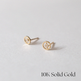 Angled view of circular gold earrings highlighting their shine and design