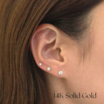 Model wearing different-sized 14K CZ studs stacked across multiple piercings