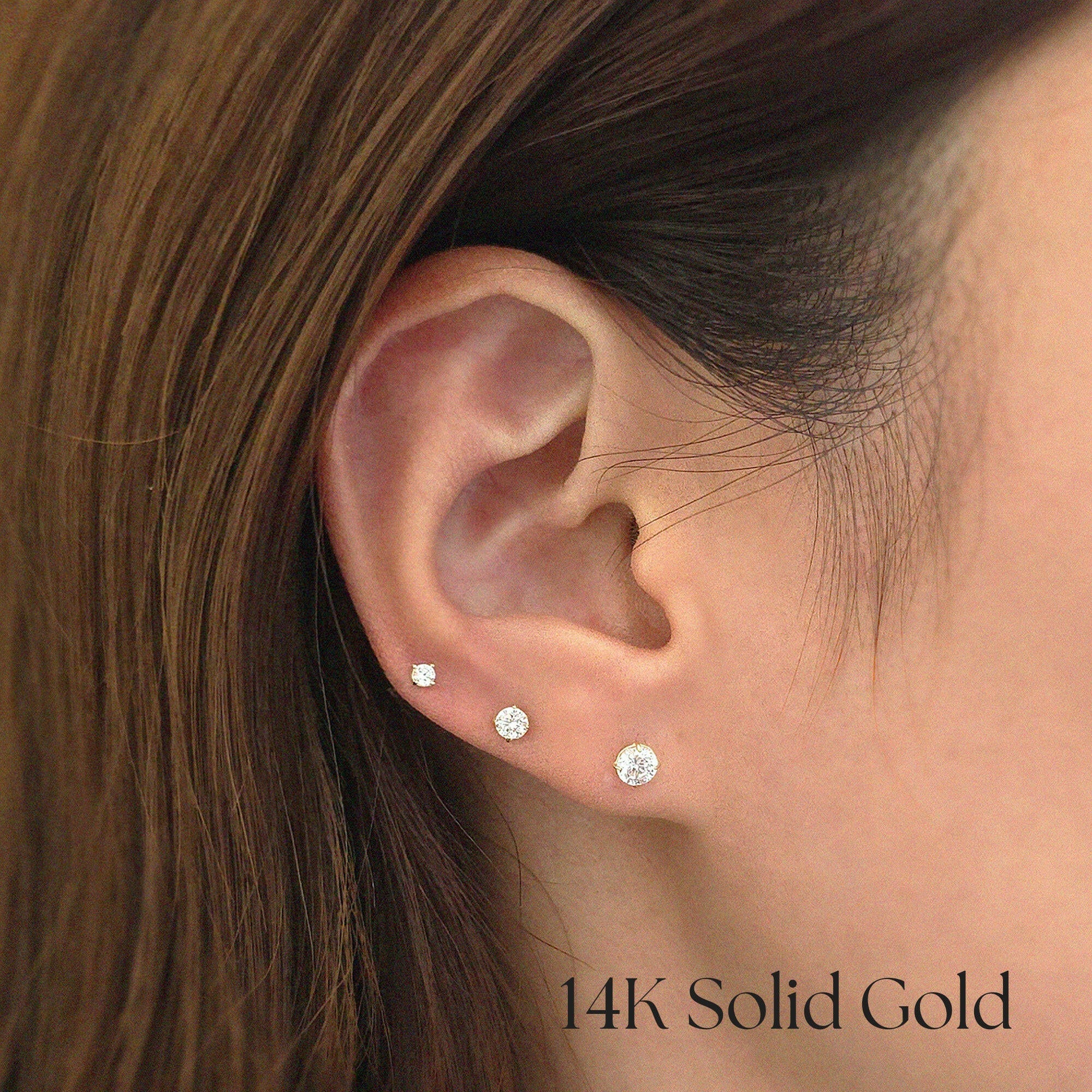Model wearing different-sized 14K CZ studs stacked across multiple piercings