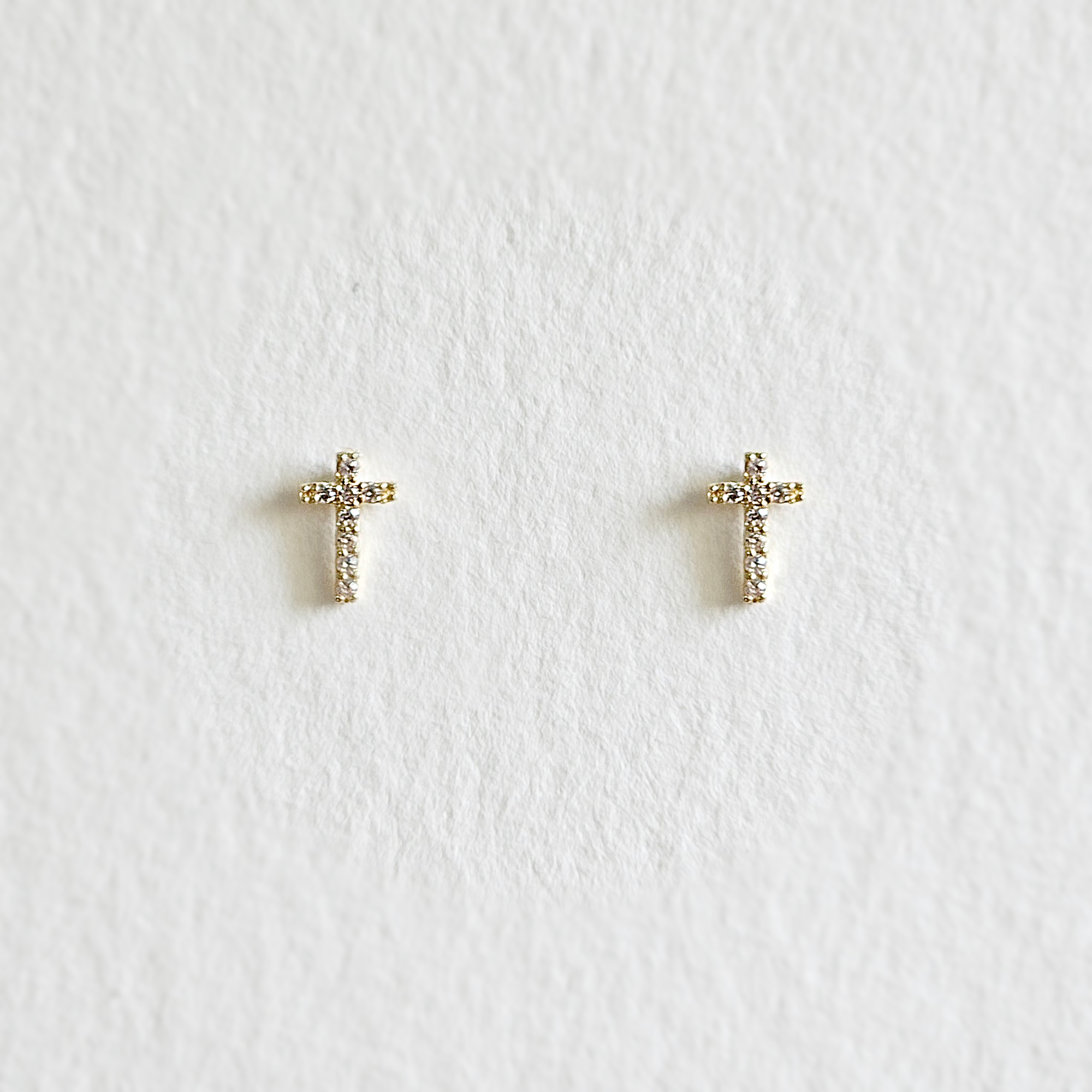 Gold cross-shaped studs with clear cubic zirconia inlay"