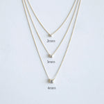 Three gold necklaces with varying diamond sizes on a white background