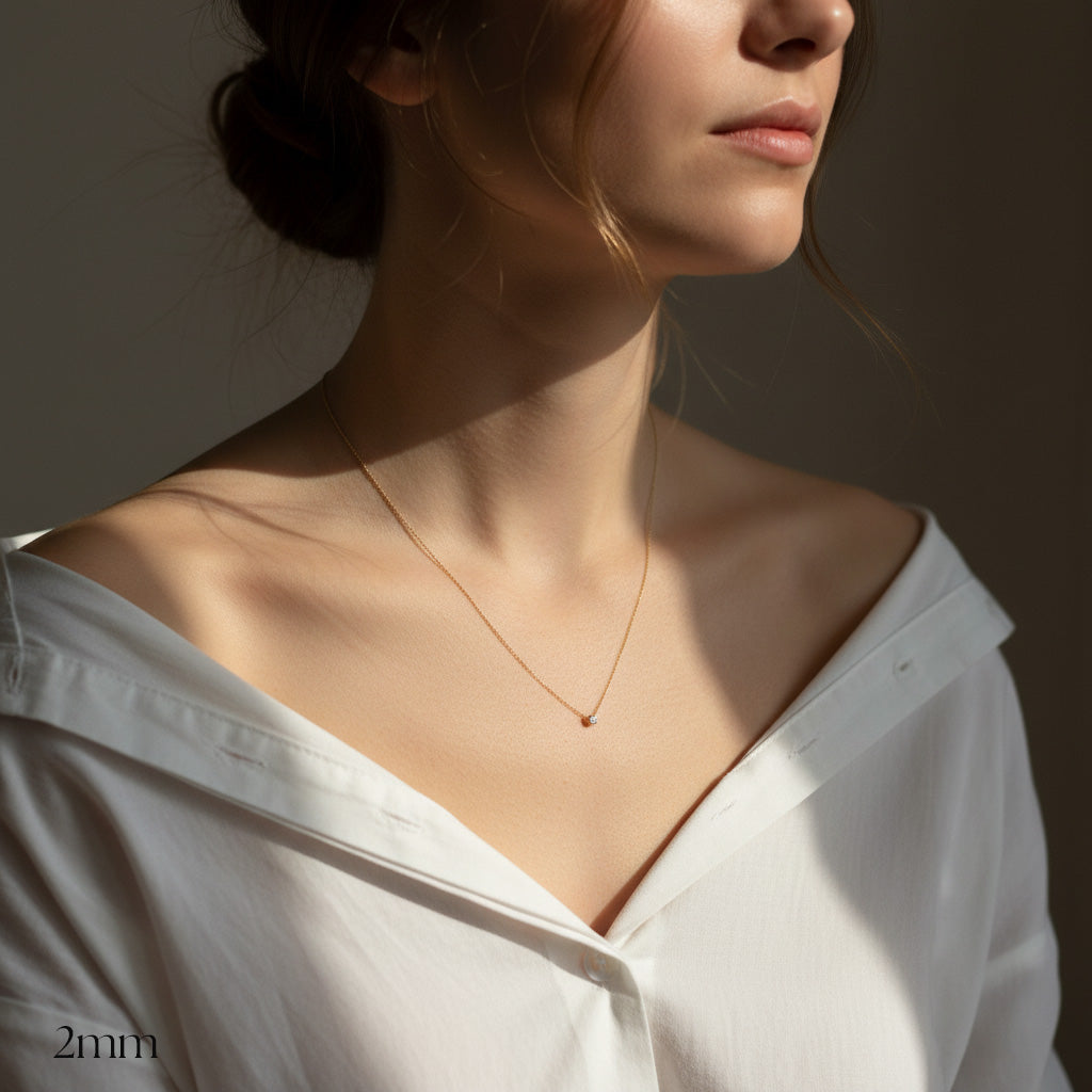 Woman wearing a delicate necklace with a plain background