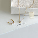 Gold necklace and earrings on a white box with 'Laondrim.com' branding.