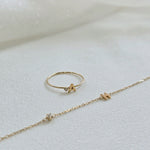 Personalized initial ring presented with initial with diamond bracelet on a soft beigh fabric