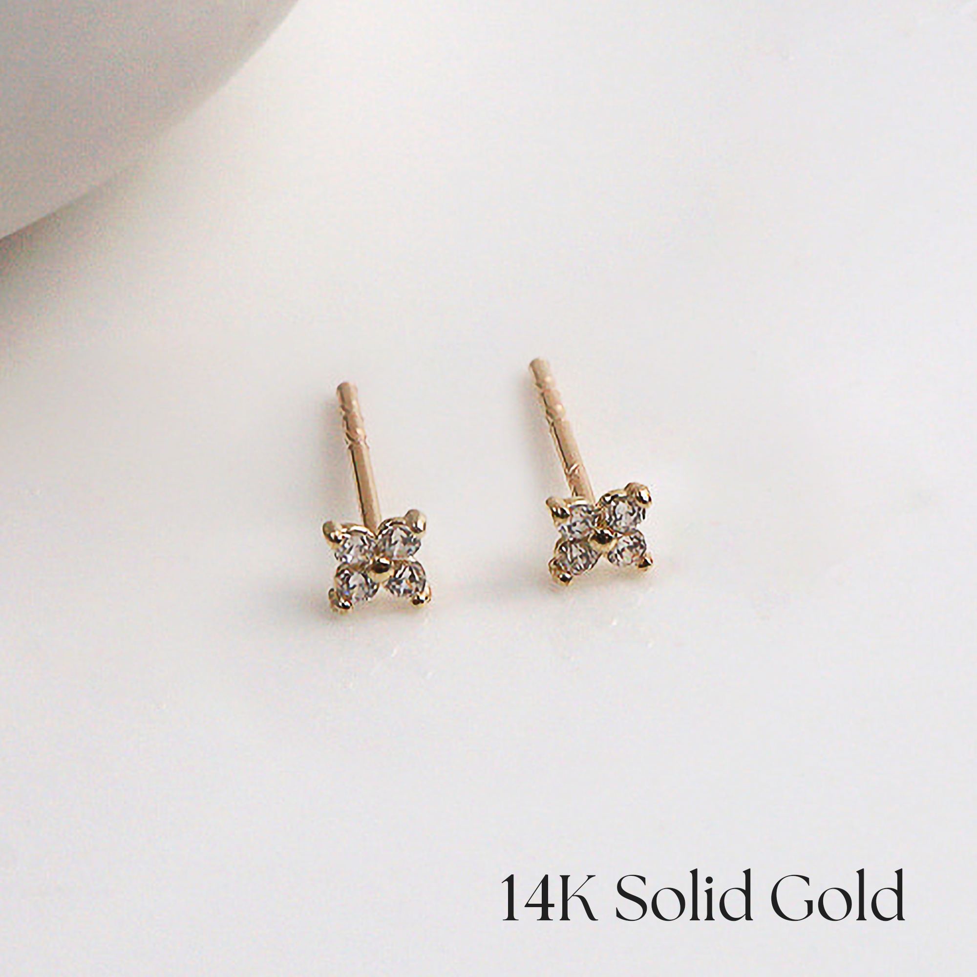 Symmetrical display of gold pansy earrings with CZ center
