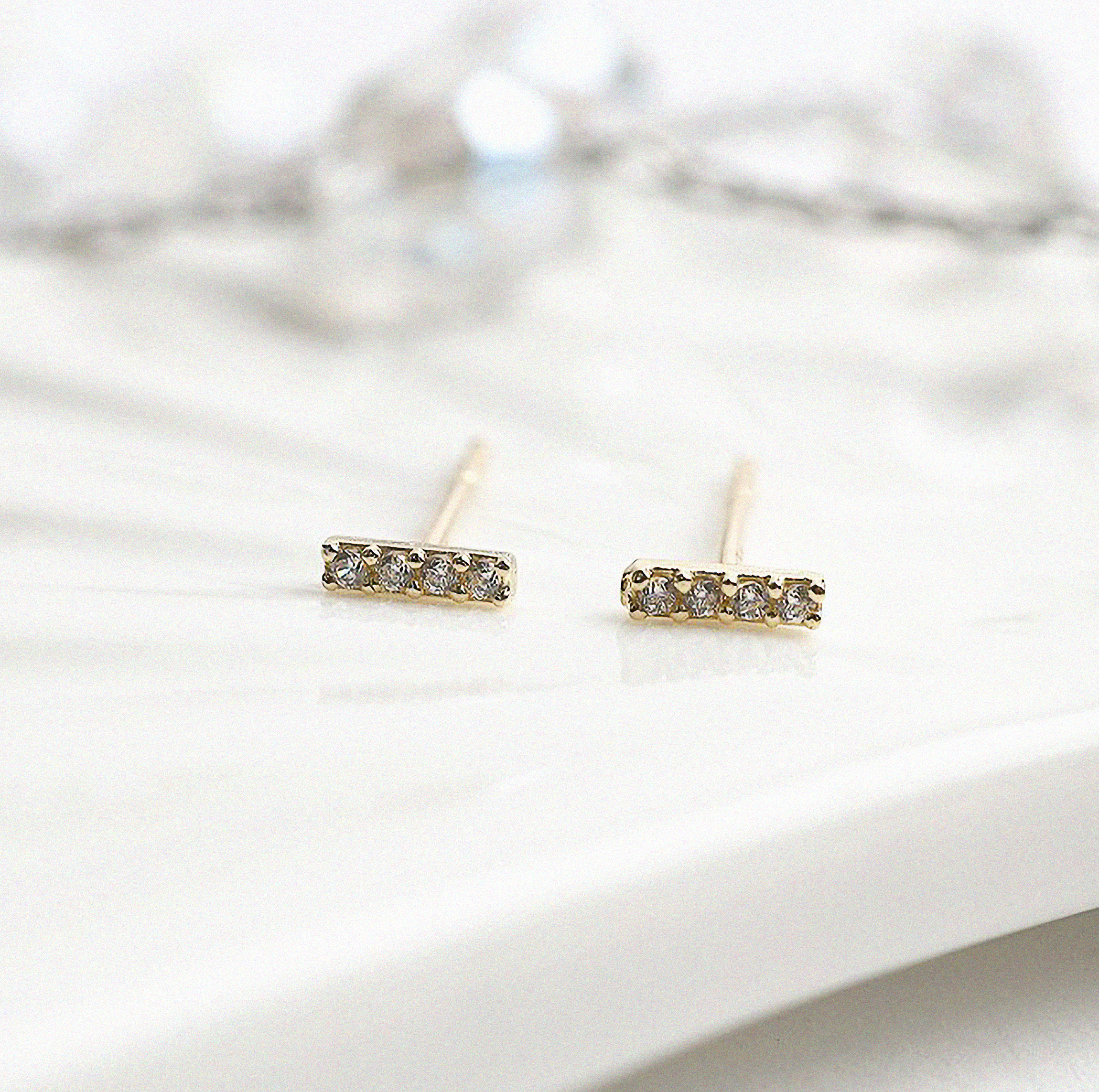 Bar-shaped gold earrings with embedded cubic zirconia details