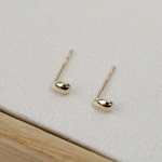 Petite gold earrings arranged from overhead to highlight shape