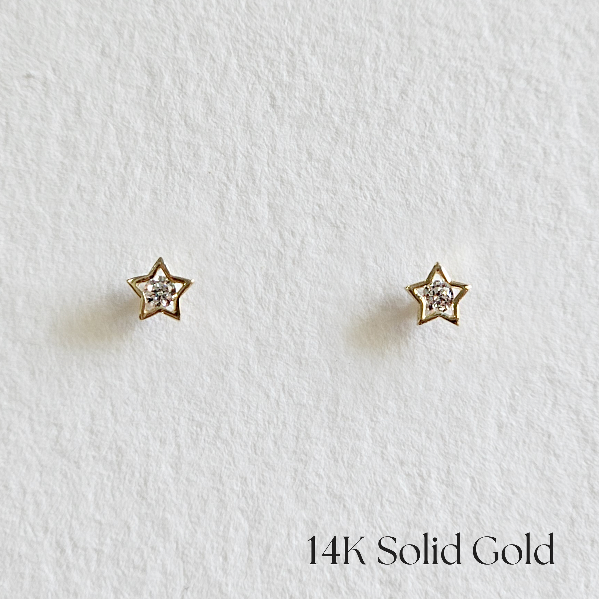 Front view of 14K gold star stud earrings with cubic zirconia center