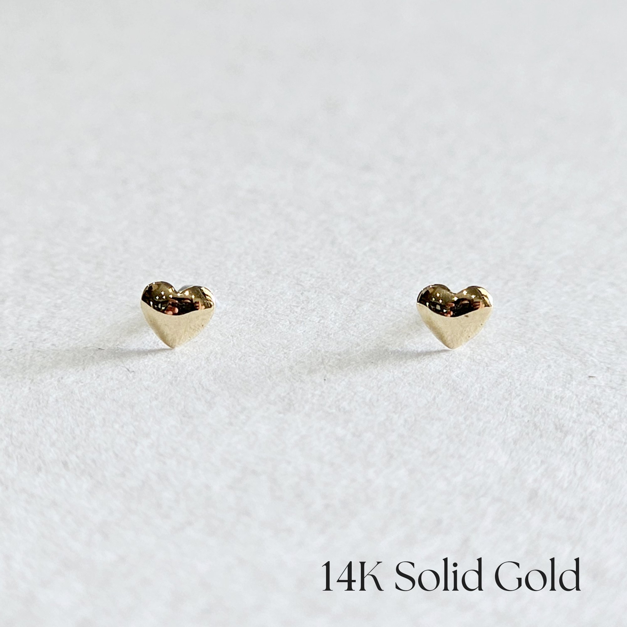 Front view of voluminous heart-shaped 14K gold stud earrings