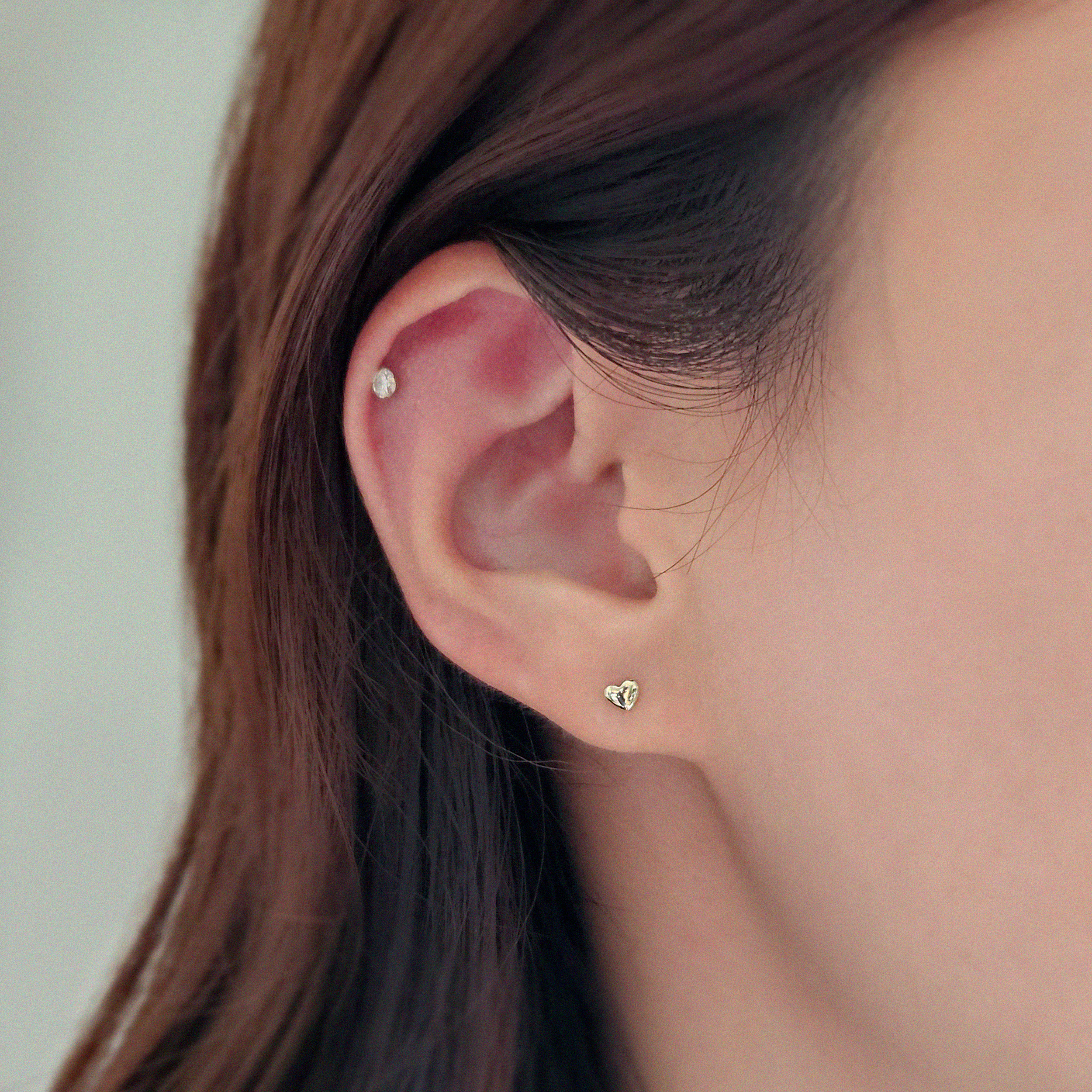 Model wearing voluminous heart studs for a sweet, minimalist look