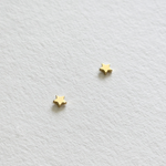 Flat lay of gold star earrings showing shine and shape