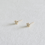 Side angle of star-shaped 14K gold earrings highlighting texture