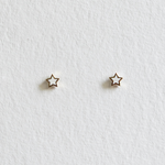 Minimalist gold star-shaped earrings photographed front-facing