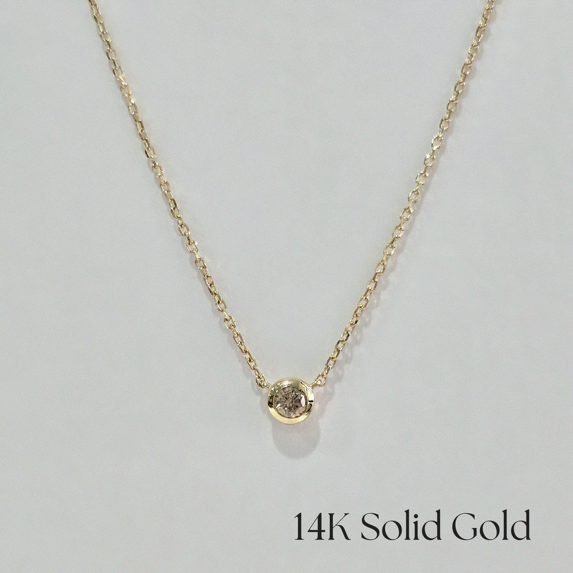 Front-facing image of full necklace – bezel diamond pendant centered on fine gold chain