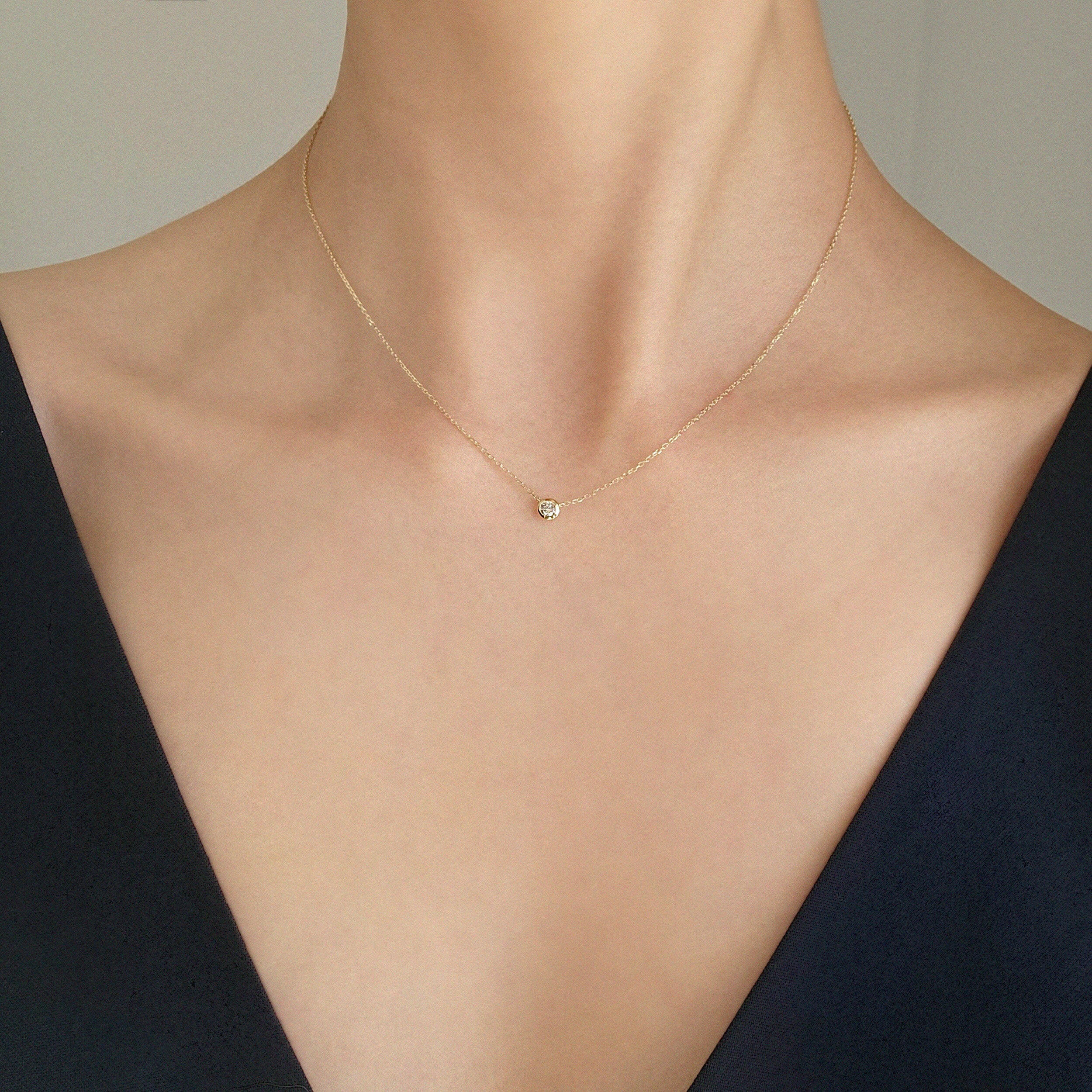 Model wearing bezel diamond pendant Necklace – pendant resting gently at collarbone for a refined look