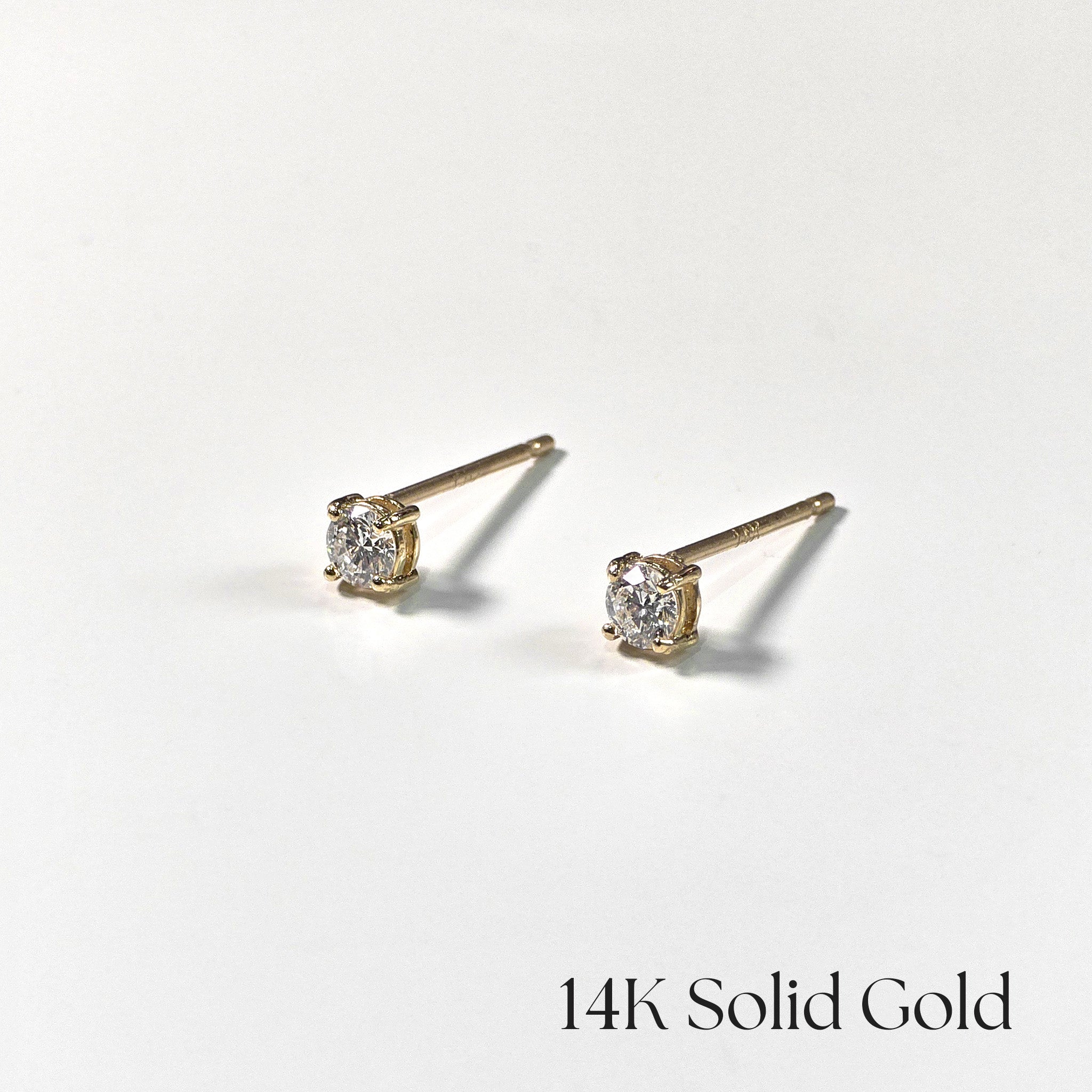 Pair of gold stud earrings with diamonds on a white background, labeled '14K Solid Gold'.