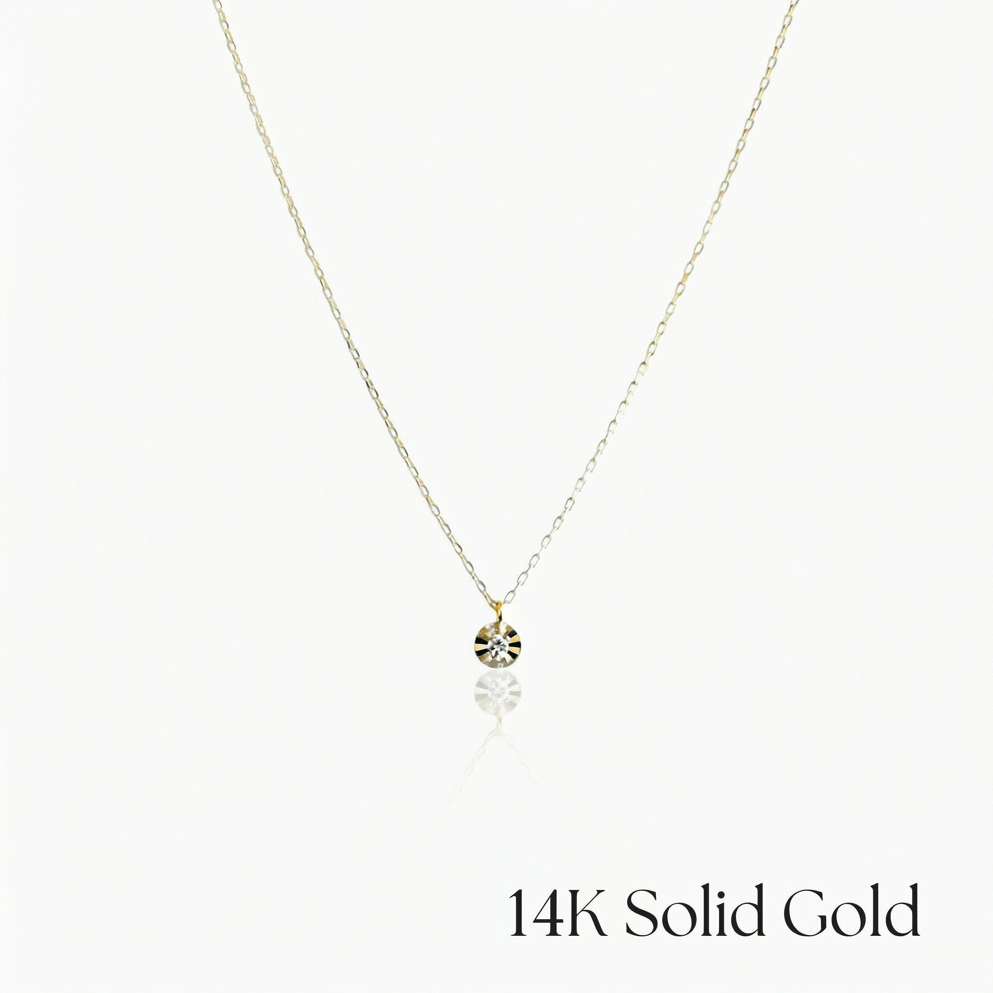 Gold necklace with a small pendant on a white background, labeled '14K Solid Gold'.
