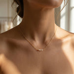 Gold necklace with pearls on a person's neck