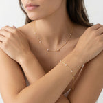 Woman wearing a gold necklace and bracelet on a white background