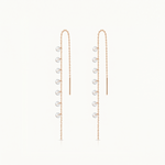 Pair of gold earrings with small round stones on a white background