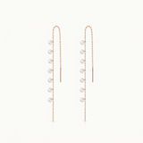 Pair of gold earrings with small round stones on a white background