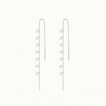 Pair of silver chain earrings with small round pendants on a white background
