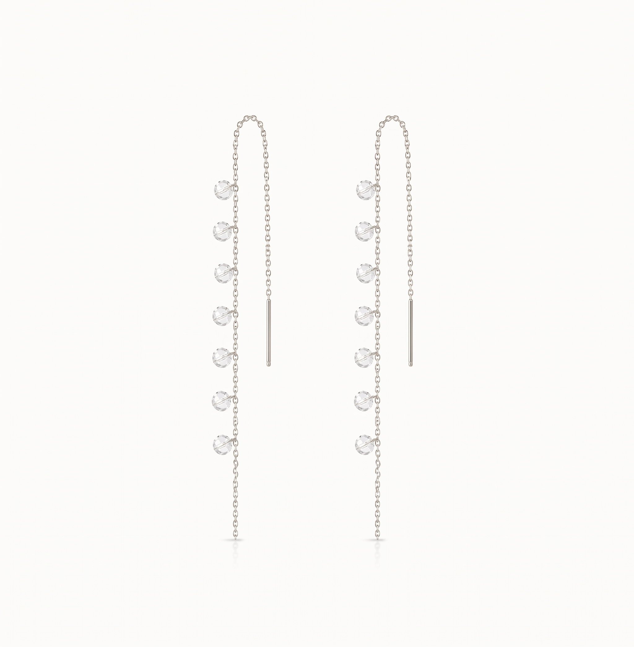 Pair of silver chain earrings with small round pendants on a white background