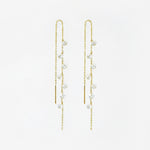 Gold chain earrings with crystal drops on a white background