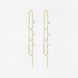 Gold chain earrings with crystal drops on a white background