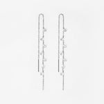 Pair of silver chain with crystal earrings on a light gray background