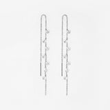 Pair of silver chain with crystal earrings on a light gray background