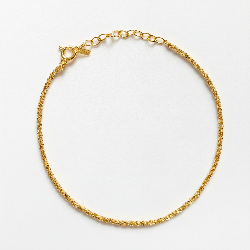 Gold chain bracelet on a light gray background