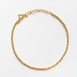 Gold chain bracelet on a light gray background