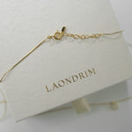 Gold bracelet on a white stand with 'LAONDRIM' branding.