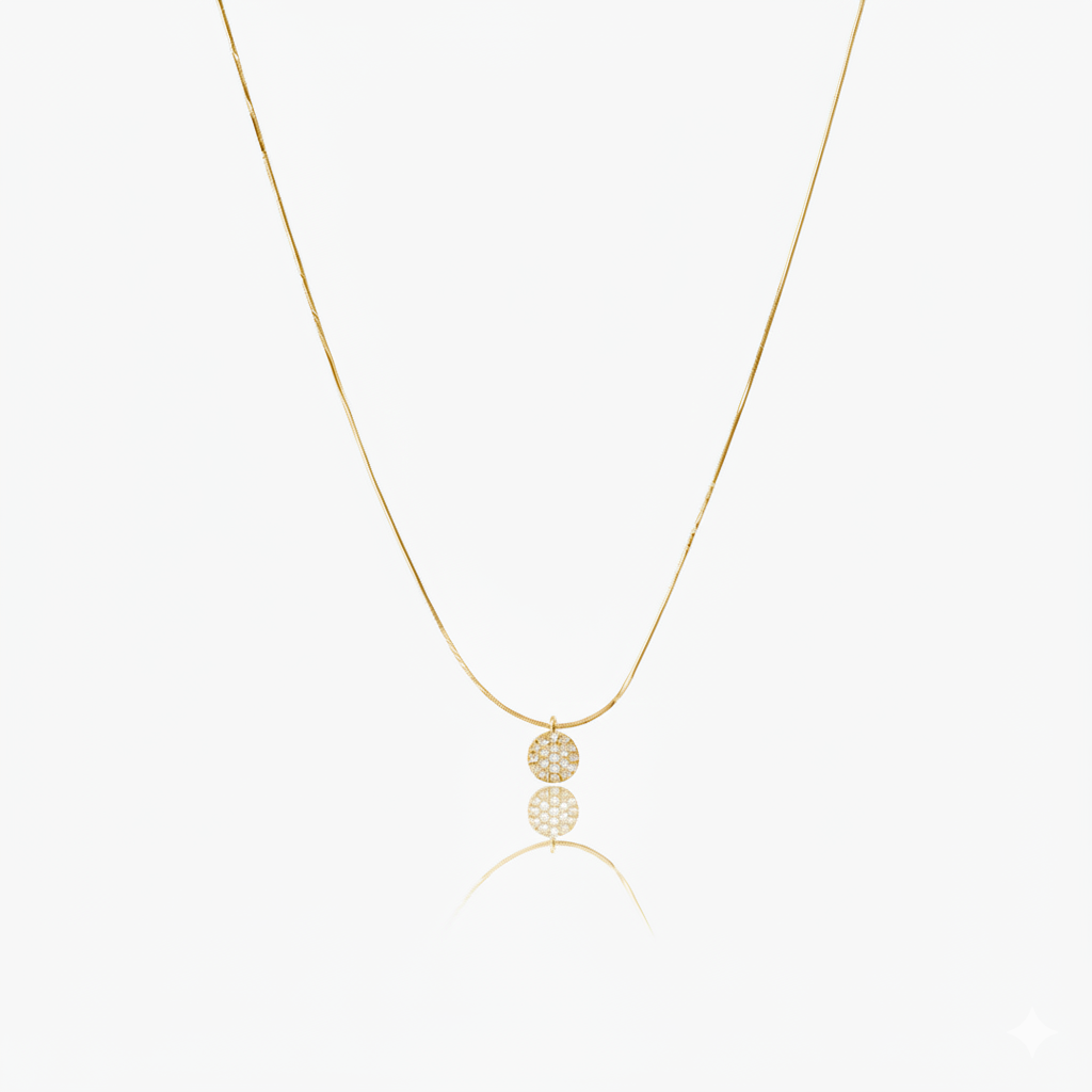 Gold necklace with  circular pendant on a white background