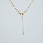 Gold necklace on a light gray background