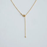 Gold necklace on a light gray background