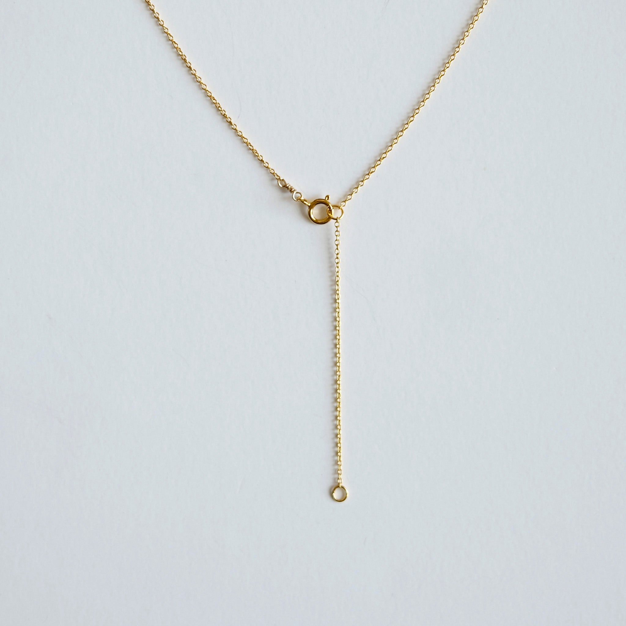 Gold necklace on a light gray background