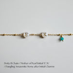 Gold chain bracelet with 'E', 'K' charms and a dangling Amazonite stone on a light gray background.