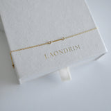 Dainty chain with small bar bracelet on a white box with 'LAONDRIM' branding