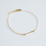 Gold bracelet on a light gray background
