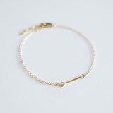 Gold bracelet on a light gray background