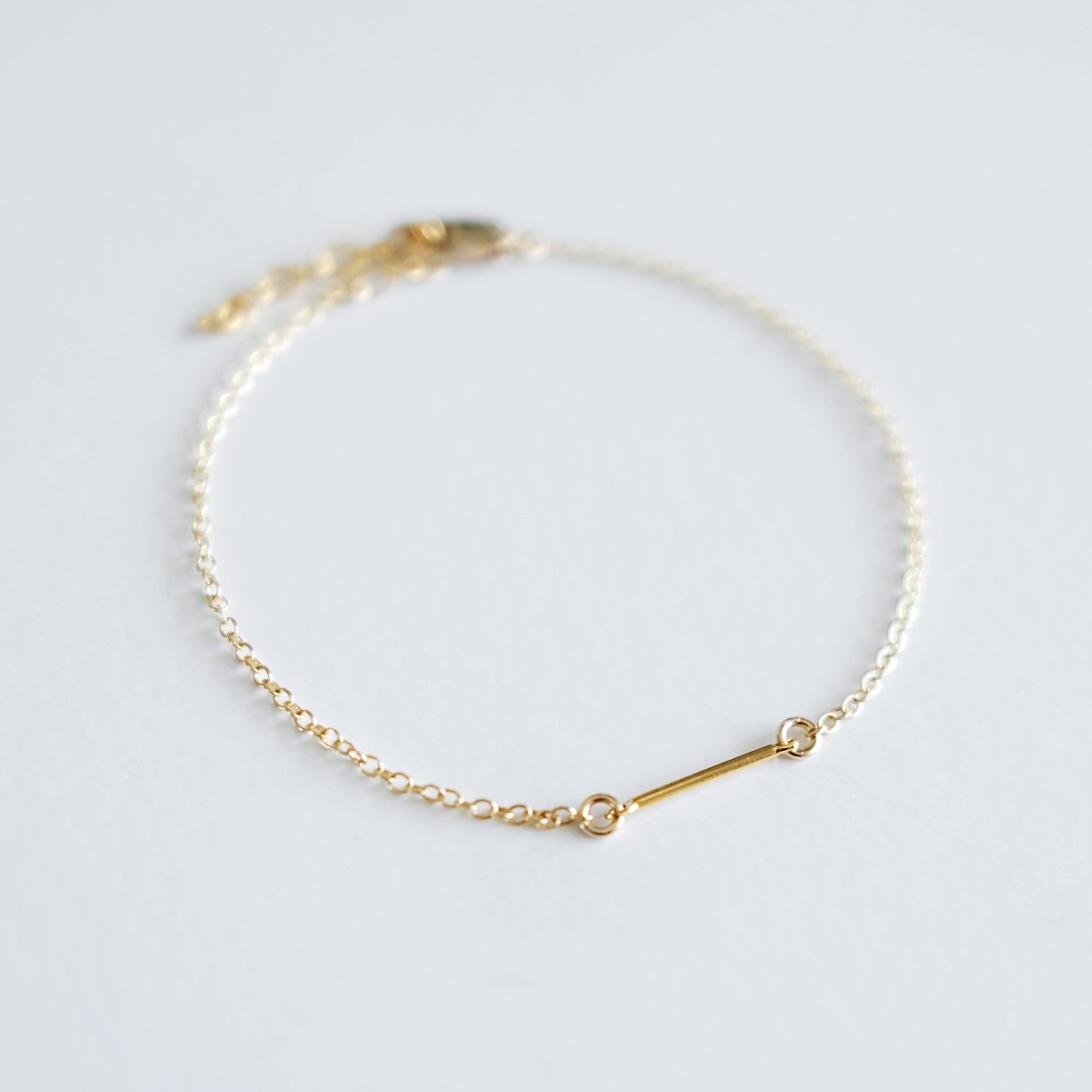 Gold bracelet on a light gray background