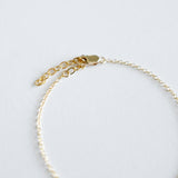 Gold bracelet on a light gray background