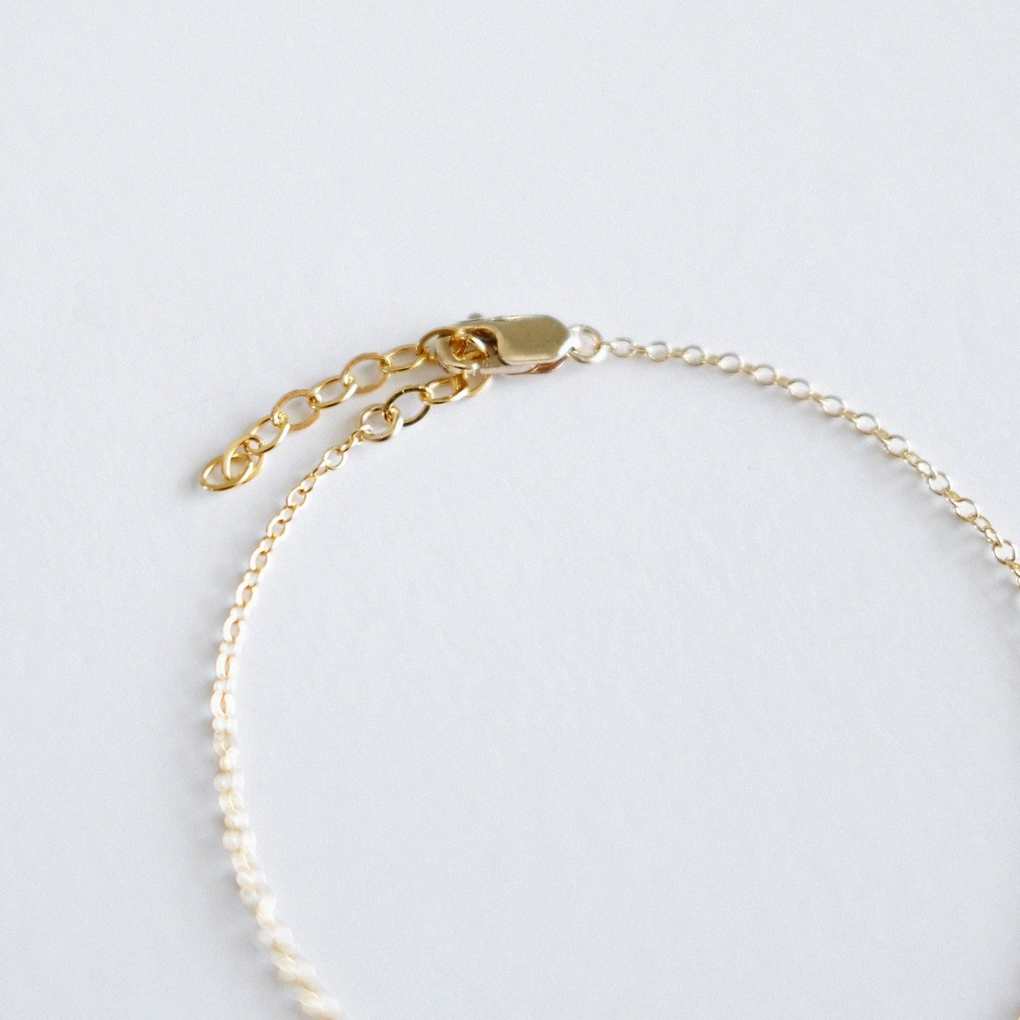 Gold bracelet on a light gray background