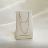 Gold necklace on a white box with a soft white background