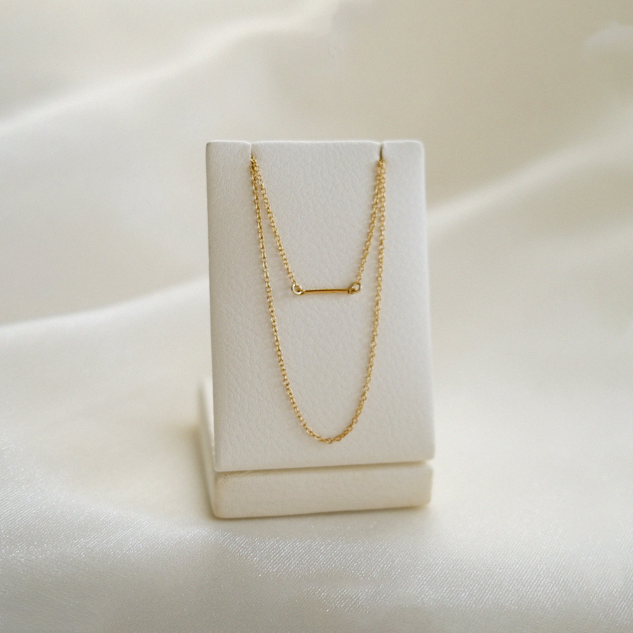 Gold necklace on a white box with a soft white background