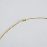 Gold chain necklace on a light gray background